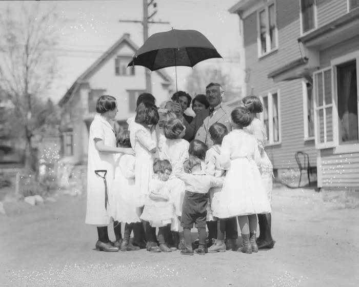There are as many as thirteen children in this family, all lined up in a row. Now look at the car…